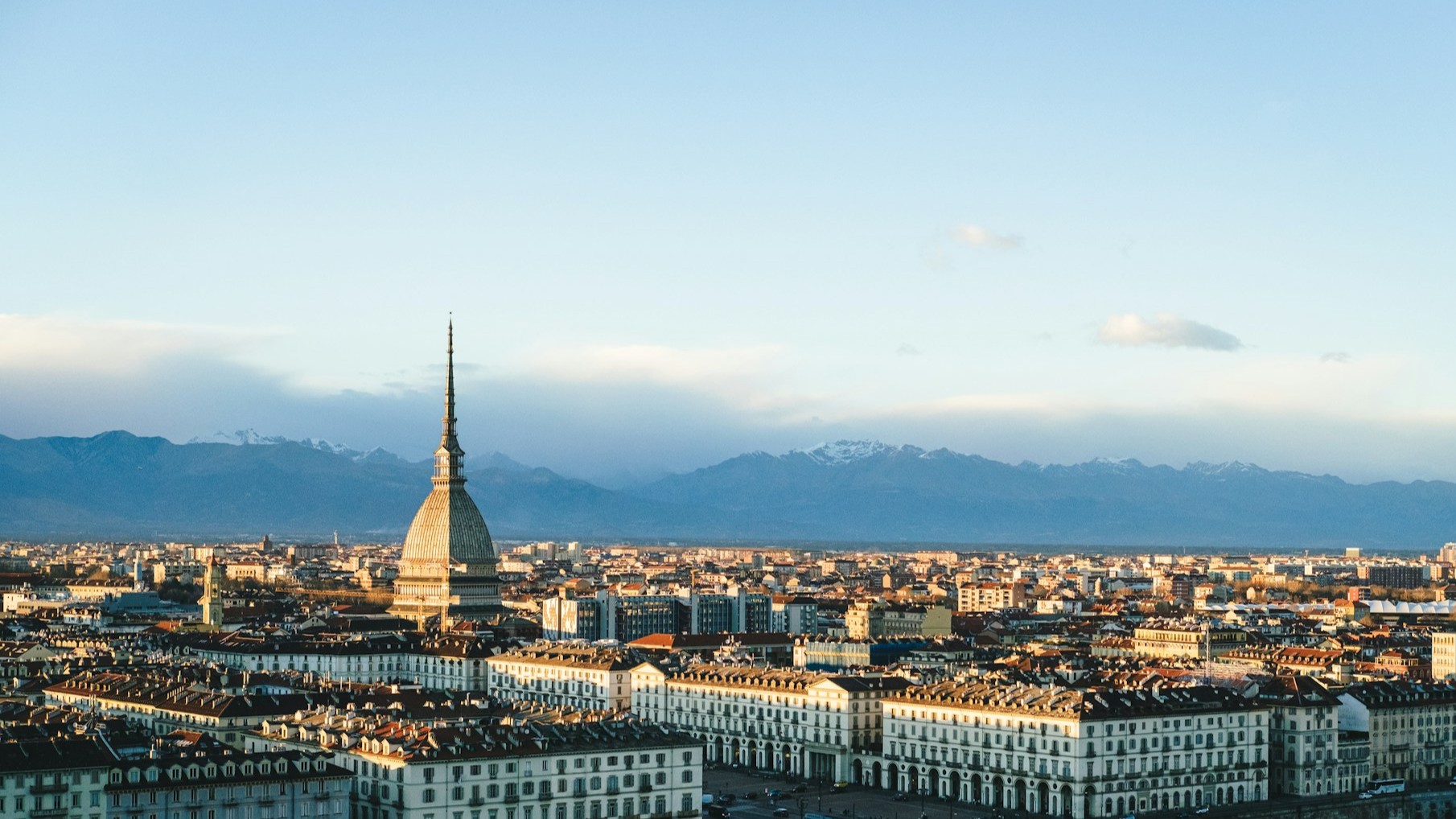 Uitzicht op Turijn met de Mole Antonelliana en de Alpen op de achtergrond in zacht avondlicht
