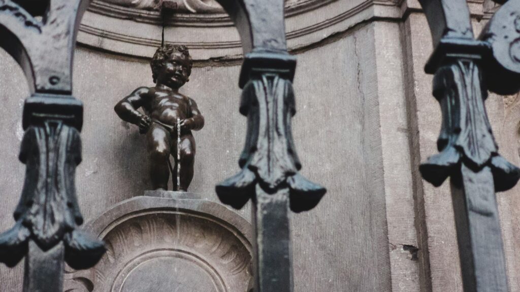 Het Manneken Pis standbeeld in Brussel, gezien door een smeedijzeren hek – een van de bekendste bezienswaardigheden Brussel.
