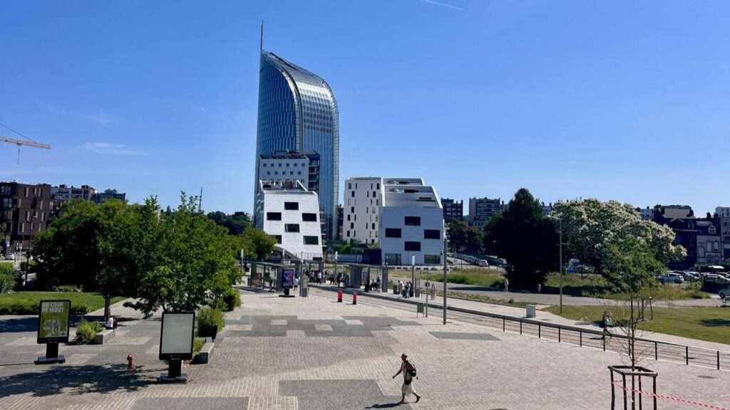 Modern stadsbeeld van Luik met opvallende toren en groene parkzone op een zonnige dag