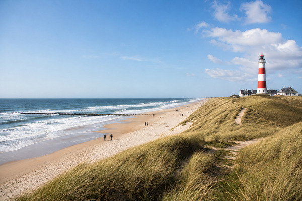 strand met vuurtoren in de duinen